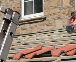 Clay roof tiles being installed